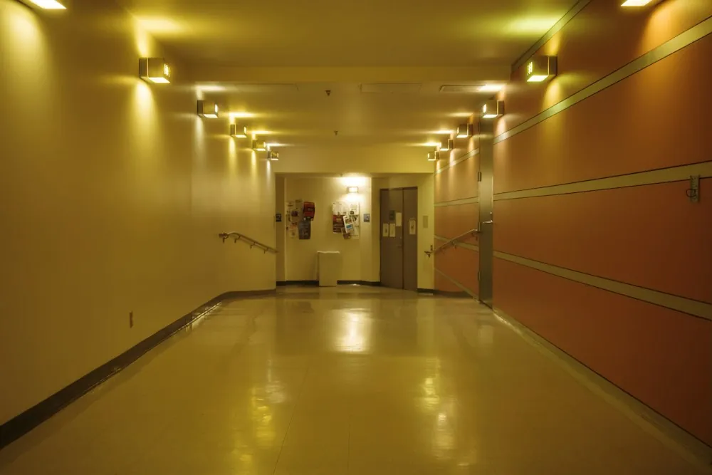 Well-lit hospital corridor with handrails along the walls
